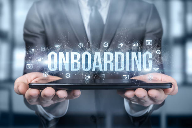 Businessman shows on the tablet the word onboarding on a blurred background.